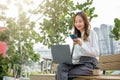 Young woman working laptop and using mobile smartphone outdoor building exterior Royalty Free Stock Photo