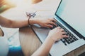 Young woman working at living room on modern computer while sitting at the wooden table.Female hands typing on laptop Royalty Free Stock Photo