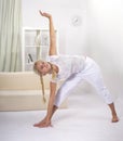 Young woman working out at home in living room. Teenager girl doing yoga or pilates exercise. Full length portrait Royalty Free Stock Photo