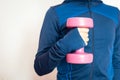 Young woman  working out at home with pink weights, on white background. sport & keeping fit Royalty Free Stock Photo