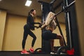 Young Woman Working Out Legs With Barbell In A Gym with instructor. Personal female trainer Royalty Free Stock Photo