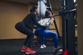 Young woman working out legs with barbell In gym with personal female trainer. Squat Exercise Royalty Free Stock Photo