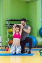 Young woman working out with personal trainer at the gym. Royalty Free Stock Photo