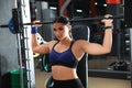 Young woman working out on Smith machine in gym Royalty Free Stock Photo