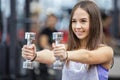 Young woman working out with two dumbbells