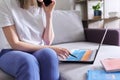 Young woman working remotely at home sitting on sofa with laptop Royalty Free Stock Photo