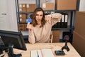 Young woman working at small business ecommerce holding credit card with angry face, negative sign showing dislike with thumbs Royalty Free Stock Photo