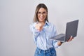 Young woman working using computer laptop pointing to you and the camera with fingers, smiling positive and cheerful Royalty Free Stock Photo