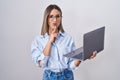 Young woman working using computer laptop thinking concentrated about doubt with finger on chin and looking up wondering Royalty Free Stock Photo