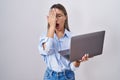 Young woman working using computer laptop yawning tired covering half face, eye and mouth with hand Royalty Free Stock Photo