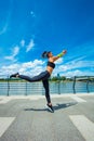 young woman workout on strainght and muscular build jumping outdoor in the city promenade by the river Royalty Free Stock Photo