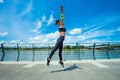 young woman workout on strainght and muscular build jumping outdoor in the city promenade by the river Royalty Free Stock Photo