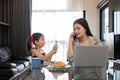 The young woman works from home, raises her daughter, and discusses work with co-workers on the phone and online. Royalty Free Stock Photo