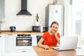 Young woman works from home using headset, laptop Royalty Free Stock Photo