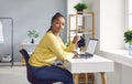 Young African American woman working from home, sitting at desk and using laptop Royalty Free Stock Photo