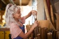 Young Woman In Workshop Assembling Hand Built Sustainable Bamboo Bicycle Frame