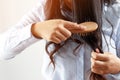 Young woman worried about Hair loss problem after comb in hand. problem hormonal disbalance, stress concept.