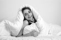 Young woman wrapped in soft blanket sitting on bed. Smiling girl sitting in bed and smiling at home. Royalty Free Stock Photo