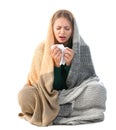 Young woman wrapped in warm blanket suffering from cold