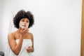 Young woman wrapped in white towel applying natural mask Royalty Free Stock Photo