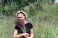 Young woman with a wreath of daisies on her head in the sun on a field of grass Royalty Free Stock Photo