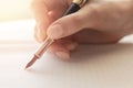 Young woman writer writes poetry with fountain pen on sheet of paper, warm sunlight Royalty Free Stock Photo