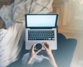 Young woman writes a text message on laptop keyboard with a empty blank screen monitor while having recreation time at home, femal