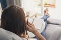 Young woman writing diary at cozy home on sofa