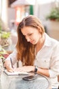 Young woman writing down into her notebook Royalty Free Stock Photo