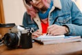 Young woman writing down notes while drinking coffee in cafe Royalty Free Stock Photo