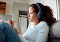 Young woman writing in her journal. Young girl writing in her diary. Woman planning in her journal. Woman listening to Royalty Free Stock Photo