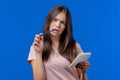 Young woman writing notes in planner with pen. Student girl thinking about future plans and to-do list in notebook for Royalty Free Stock Photo