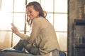 Young woman writing sms in loft apartment