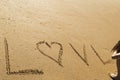 Young woman writing the word love in the sand of a beautiful beach Royalty Free Stock Photo