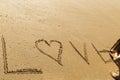 Young woman writing the word love in the sand of a beautiful beach Royalty Free Stock Photo