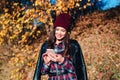 Young woman writting sms on mobile phone in autumn park. Royalty Free Stock Photo