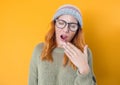 Young woman yawns. Sleepy girl yawning, isolated on yellow background Royalty Free Stock Photo