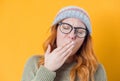 Young woman yawns. Sleepy girl yawning, isolated on yellow background Royalty Free Stock Photo