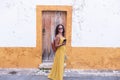 Young woman in yellow dress walking with smart phone on the old streets in the city. Portugal. Travel concept Royalty Free Stock Photo