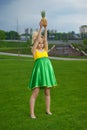 Young woman in yellow-green dress with pineapple