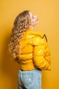 Young woman in yellow jacket on bright yellow background. Positive emotion Royalty Free Stock Photo