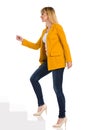 Young Woman In Yellow Jacket And High Heels Is Walking Up The Stairs. Side View Royalty Free Stock Photo