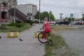 A young woman with a yellow mountain bike is riding along the sidewalk. A walk on a bicycle in the park. Girl with