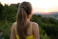 Young woman in yellow summer dress standing in green meadow enjoying sunset view Royalty Free Stock Photo