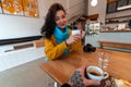 Young Woman in Yellow Sweater And Blue Scarf Drinking Hot Tea at Modern Cafe And Looking at Boyfriend. First Person View Royalty Free Stock Photo