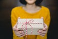 Young woman in yellow sweater holding gift box for spacial event