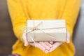 Young woman in yellow sweater holding gift box for spacial event