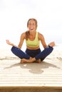 Young woman in yoga pose at the beach and laughing Royalty Free Stock Photo