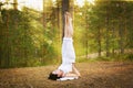 Young woman in Yoga shoulder stand in forest Royalty Free Stock Photo