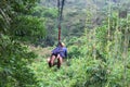 Young woman on zipline above the jungle Royalty Free Stock Photo